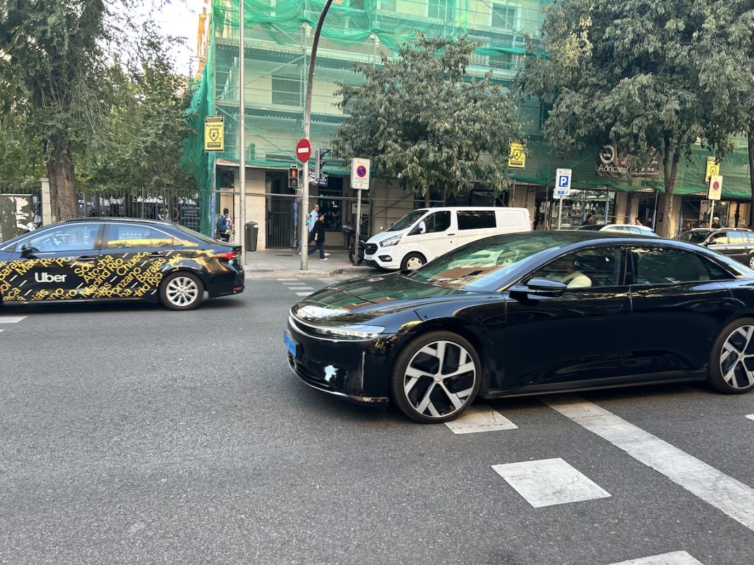 Un vehículo eléctrico Lucid Air circulando por una calle de Madrid al lado de un coche de Uber @FLEET PEOPLE TODOS LOS DERECHOS RESERVADOS