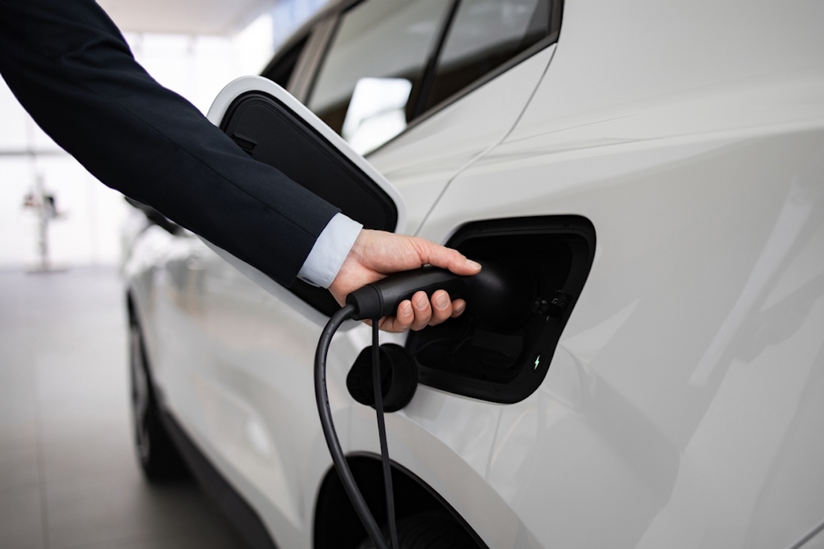 Business,Professional,Displaying,Electric,Car,At,Vehicle,Dealership.,Hand,Connecting