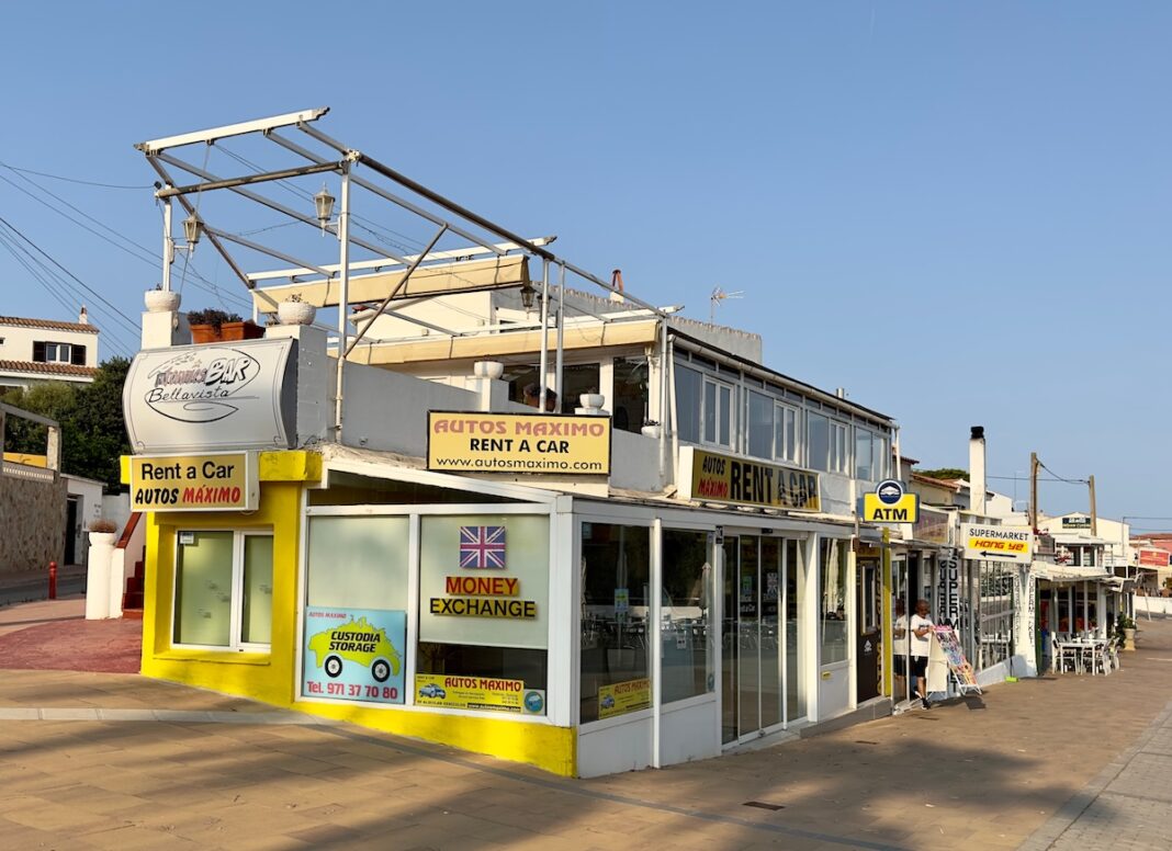 Un centro comercial con una oficina de rent a car, en Cala en Porter, en Menorca. FOTOGRAFÍA Nigel J. Harris